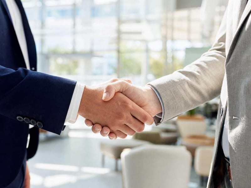 Owner and operator handshake confirming a first-workflow agreement.